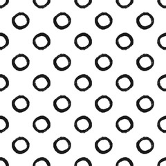 Repeated circles drawn with a rough brush. Trendy seamless pattern. Grunge, ink, sketch, watercolor, paint. Black round shape on a white background.