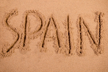 Spain written in soft wet sand on a beach
