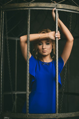 Портрет красивой девушки в вечернем синем платье в интерьерной студии 