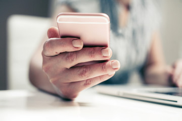 Close up of hand using smart phone. Caucasian business woman.