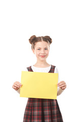 Portrait of smiling girl in school uniform holding blank paper against white background