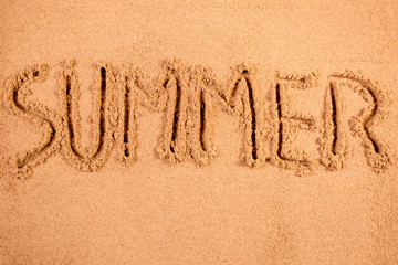 Fototapeta premium Summer written in soft wet sand on a beach