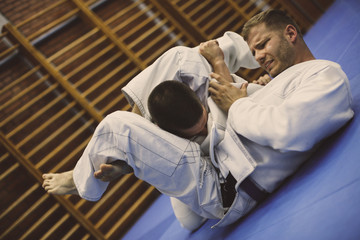 Two young males practicing judo together.