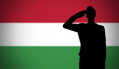 Silhouette of a soldier saluting against the hungary flag