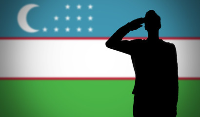 Silhouette of a soldier saluting against the uzbekistan flag