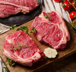 Raw beef meat on a dark wooden board.