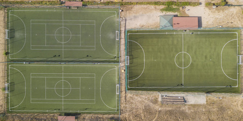 Vista aerea perpendicolare di tre campi di calcio a 5 in erba sintentica. A bordo campo panchine e...