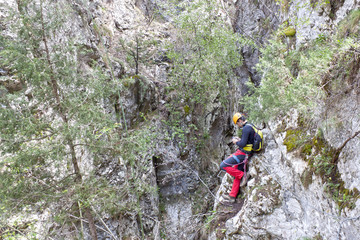 mountaineer checking his GPS in the mountain in a via ferrata