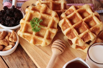 Waffles topped with honey, raisins and cashews.