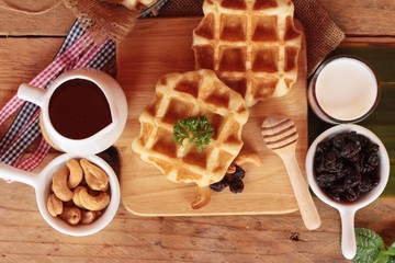 Waffles topped with honey, raisins and cashews.