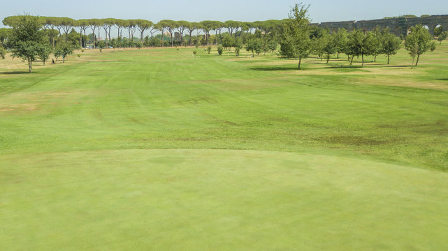 Panoramica di un campo verde e rigoglioso. Questo terreno è parte di un circolo sportivo di golf a Roma, in Italia.