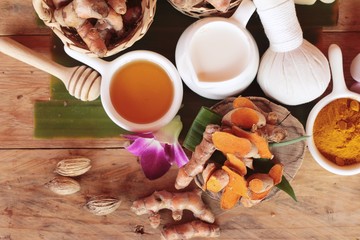 Turmeric root with turmeric powder on wood background