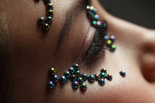 Woman portrait with pearl beads on her skin. Creative makeup