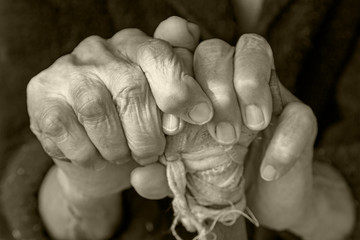 Hands of an elderly woman on a cane