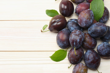 raw plum on white wooden table. top view with copy space