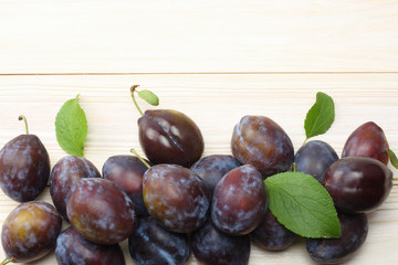 raw plum on white wooden table. top view with copy space
