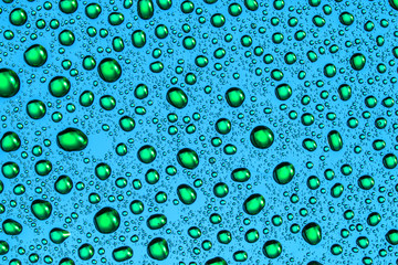 Green water drops on blue bright glass surface pattern background.