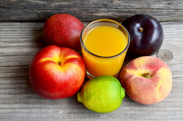 Fresh ripe fruits and a glass of juice.Multi fruit juice.Juice mix fruit on old wooden table.Healthy drink or diet concept.Selective focus.