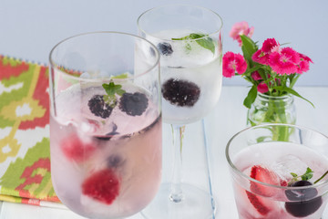 Glasses of water with ice cubes with fresh berries.