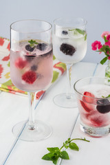 Glasses of water with ice cubes with fresh berries.