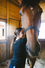 Beautiful brunette girl with her horse. 