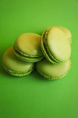 Tasty macarons on green background