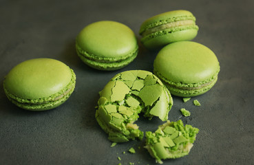 Tasty green macarons on gray background