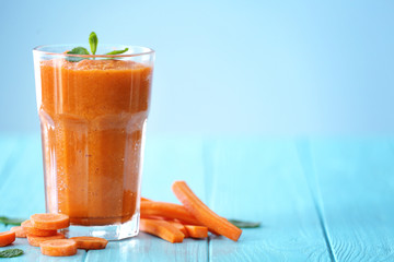 Glass with fresh tasty carrot smoothie on table
