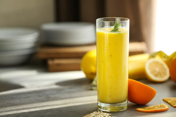 Glass with fresh tasty fruit smoothie on table