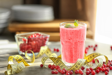 Glass with fresh berry smoothie on table