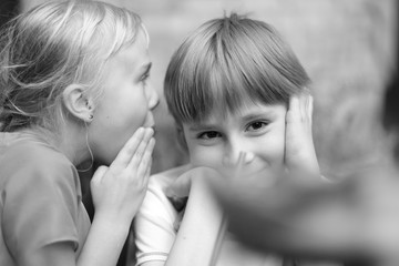 Secret children's conversation at a table in a summer cafe