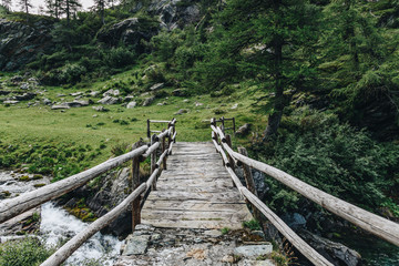 Fototapeta na wymiar A wood bridge in mountain. Italy.