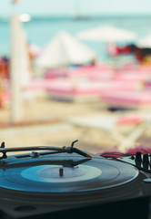 Summer beach dj party. Vinyl record and turntable close-up. Shallow depth of field