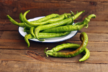Green peppers on wooden background