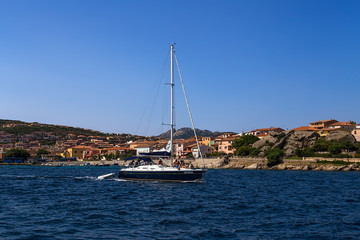 Sardinia, Italy. Yacht against the backdrop of a picturesque shore