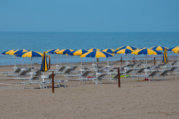 Liegestühle und Sonnenschirme morgens am Strand 