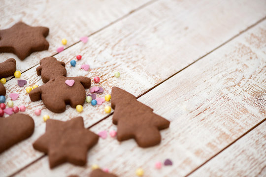 Christmas gingerbread cookies with different shapes over a white vintage wooden table