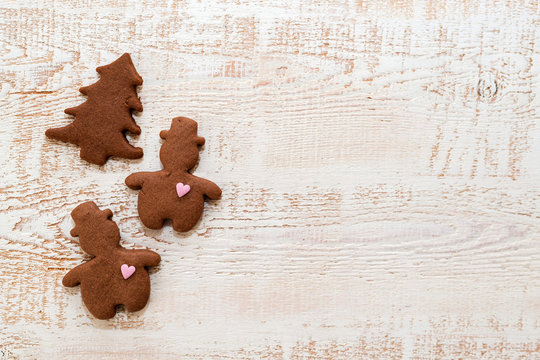 Christmas gingerbread cookies with different shapes over a white vintage wooden table