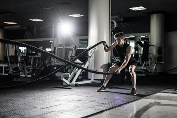 Obraz na płótnie Canvas Crossfit battling ropes at gym workout exercise. Crossfit