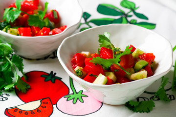 Tomato cucumber salsa in ceramic bowl.