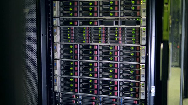 A tower full of hard drives behind a glass door.    
