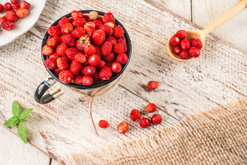 Ripe berries in a Cup on light rustic background.