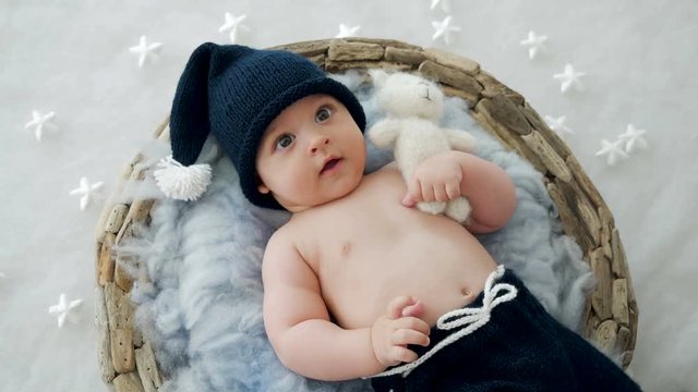 baby boy lying in a basket with fur hat-knitting gnome in my pants