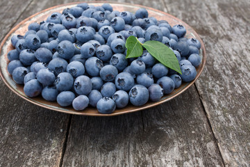 Blueberries in a plate on a wooden table
