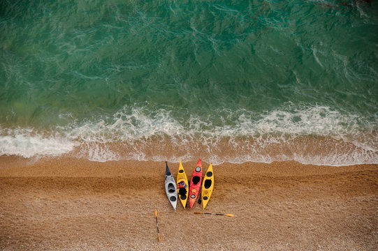 Colorful kayaks on sandy beach. Aquasport.