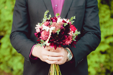 Groom hugs bride with wedding bouquet