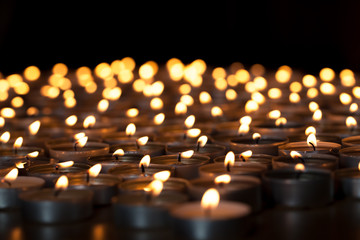 Flaming candles. Spiritual image of tealights providing sacred light. Romantic candlelight at night.