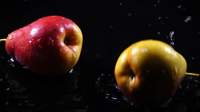 Amazing couple of Forella pears, falling on black surface with shallow water on dark background in back-light. Excellent slow motion for vibrant intro in HD. Shooting with high-speed, 240fps, camera.