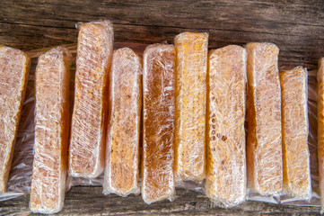Honey with honeycombs packed in plastic wraps