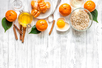 Preparing healthy breakfast. Cereals with oranges, honey, cinnamon on wooden table background top view copyspace